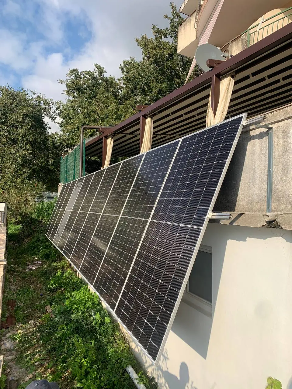 Solar panels on the wall of the house among the trees