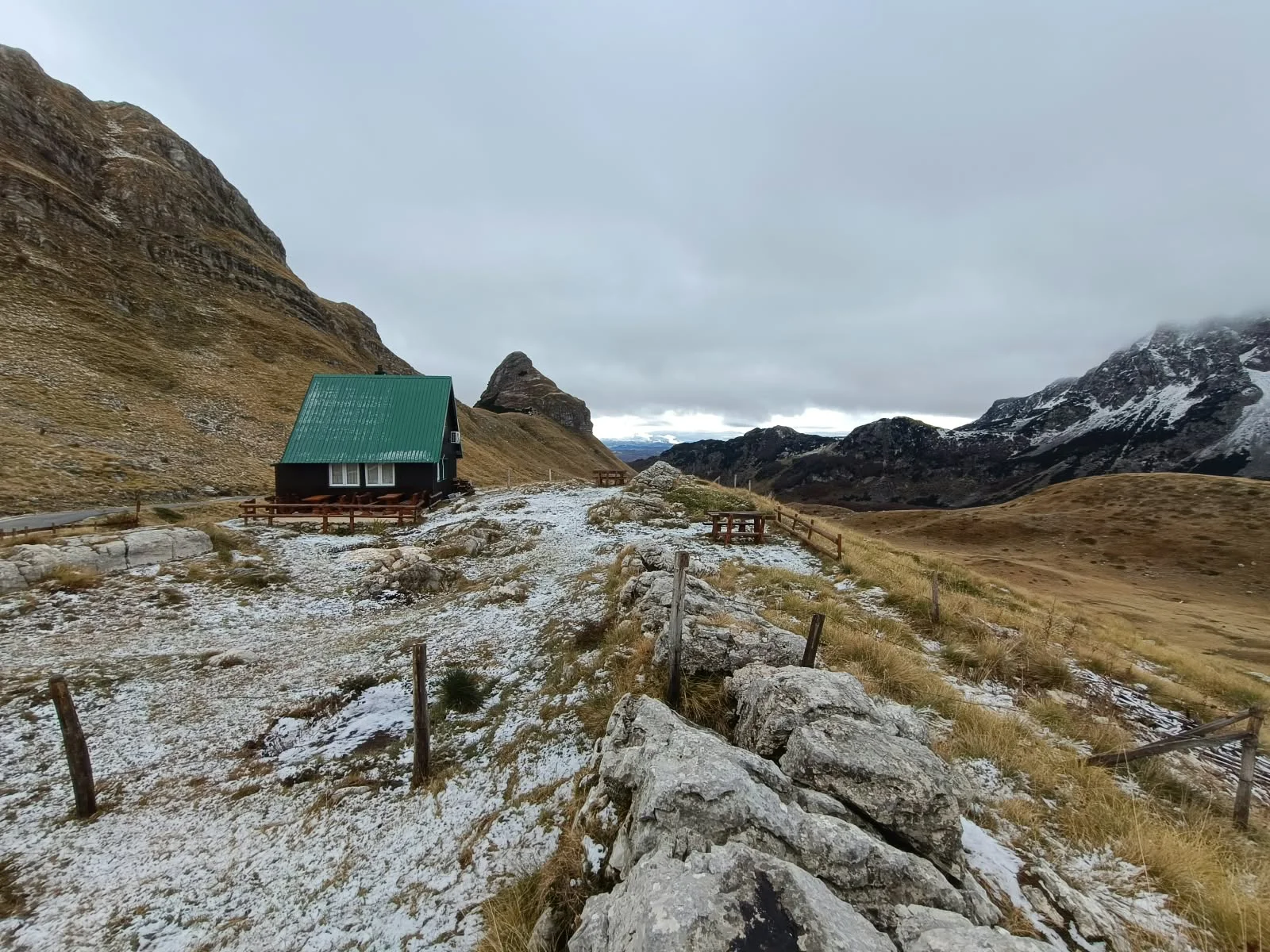Konoba with a green roof on a rocky slope at Sedlo Pass after the first snow